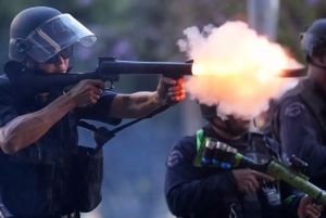Agente de policía dispara una bala blanda hacia el Centro de Detención Metropolitano en Los Ángeles. Foto Ap / Eric Thayer